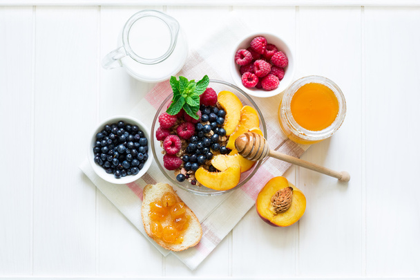 Healthy breakfast: muesli with honey, milk and fresh berries in a bowl - Foto, Imagem