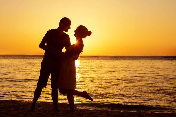 Romantický pár na pláži při barevném západu slunce na pozadí - Fotografie, Obrázek