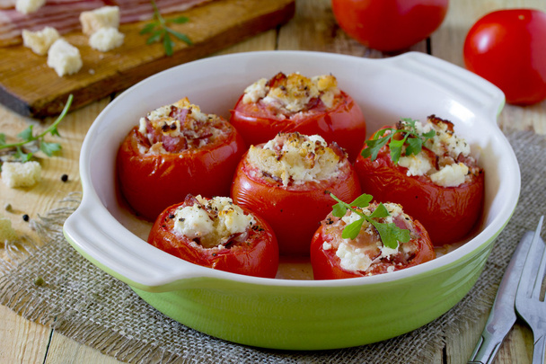 Baked stuffed tomatoes with bacon and feta cheese on rustic tabl - Photo, Image