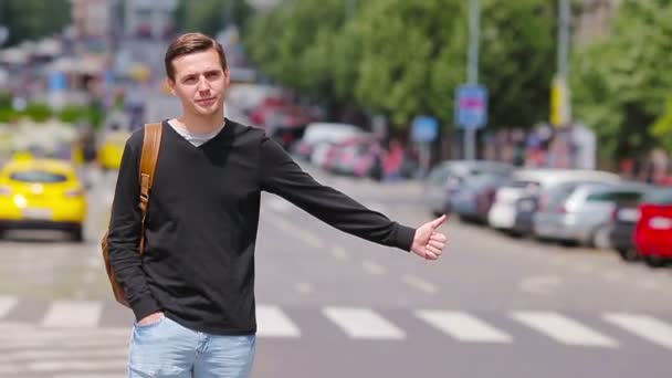 Giovane uomo felice prendere un taxi nelle strade europee. Ritratto di turista caucasico con zaino sorridente e prendere un taxi
 - Filmati, video
