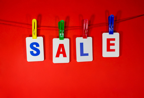 Sale paper label from cards hanging on red background, discount banner. - 写真・画像