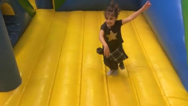 Молодая девушка прыгает на прыгающий замок
 - Кадры, видео