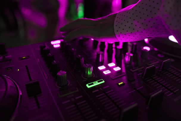 DJ mixy na torze w nocnym klubie, na imprezie z tańcami ludzi na rozmycie tła - Zdjęcie, obraz