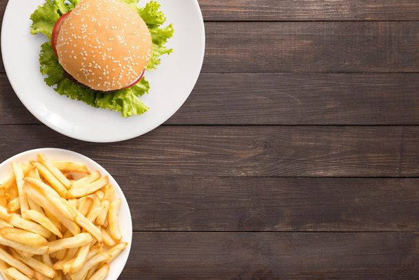 Top view bbq hamburger and french fries on the wooden background - Foto, Imagem
