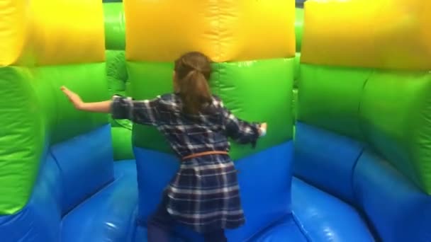 Молодая девушка прыгает на прыгающий замок
 - Кадры, видео