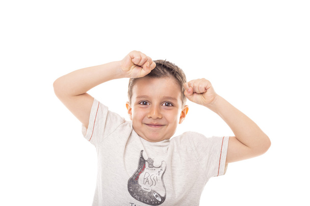 Πορτρέτο ενός ενθουσιασμένου χαριτωμένο αγόρι με τα χέρια ψηλά απομονώνονται σε λευκό φόντο - Φωτογραφία, εικόνα