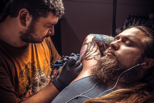 Tatuaje profesional hace tatuaje fresco en salón de tatuaje
 - Foto, Imagen
