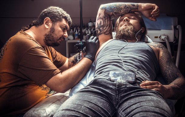 Tatuaje en el trabajo en el salón de tatuajes
 - Foto, Imagen