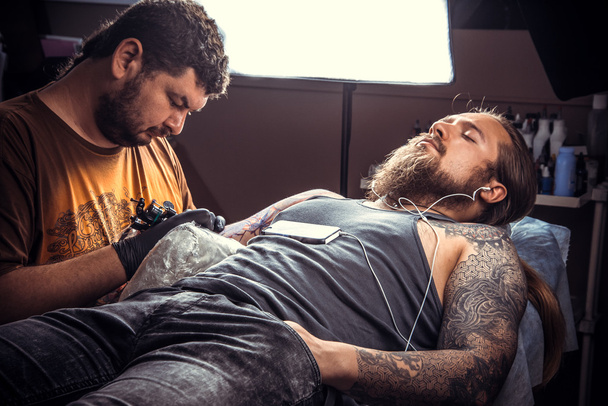 Tatuaje artista trabaja en salón de tatuajes
 - Foto, Imagen