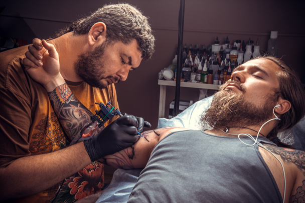 Master makes cool tattoo in tattoo studio - Photo, Image