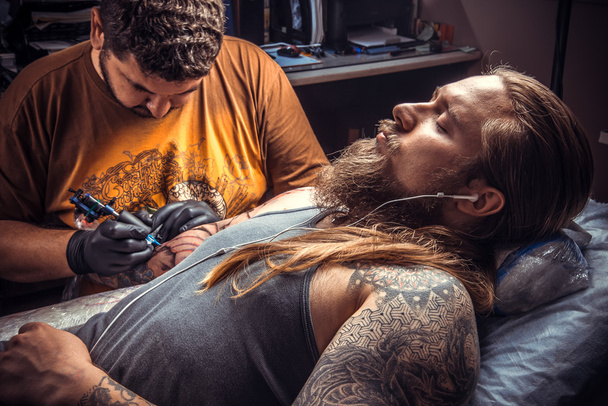 Maestro del tatuaje posando en estudio
 - Foto, Imagen
