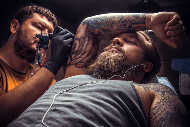 Τατουαζ master κάνουν ένα τατουάζ στην αίθουσα δερματοστιξιών - Φωτογραφία, εικόνα
