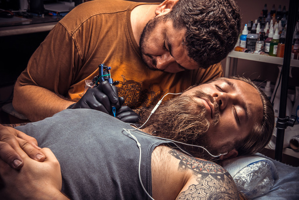 Tatuaje artista trabajando tatuaje en salón de tatuajes
 - Foto, Imagen