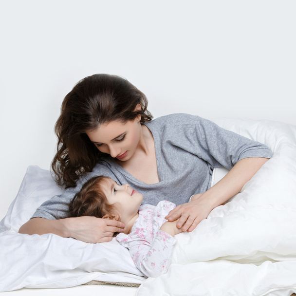 Beautiful mother and daughter in bed - Photo, Image