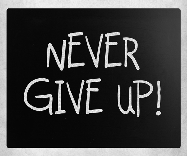 "Geef nooit op "handgeschreven met wit krijt op een Blackboard - Foto, afbeelding