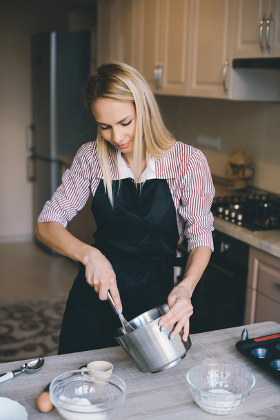 Молодая женщина шеф-повар варить торт на кухне
 - Фото, изображение