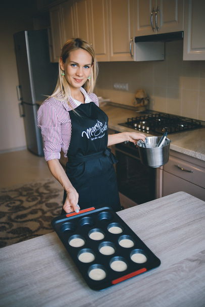 Young woman chef cooking cake in kitchen - Valokuva, kuva