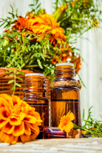Μικρό μπουκάλι λάδι απαραίτητο marigold (Tagetes λουλούδια εκχύλισμα, βάμμα, έγχυση) - Φωτογραφία, εικόνα