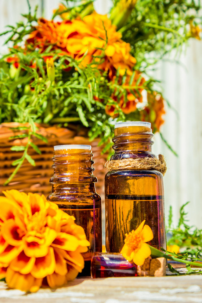 Pequena garrafa de óleo de calêndula essencial (extrato de flores Tagetes, tintura, infusão
) - Foto, Imagem
