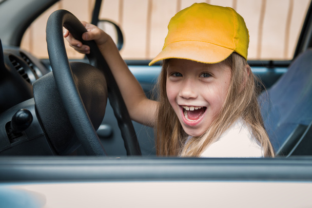 Portret wesoły małej dziewczynki za kierownicą samochodu - Zdjęcie, obraz