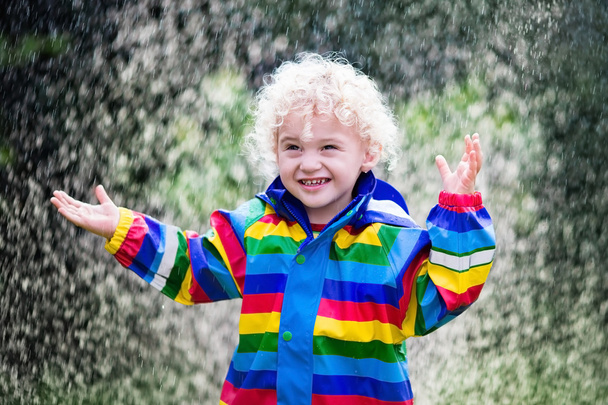 Little boy playing in the rain - Photo, image