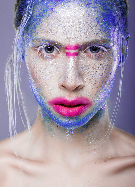 Beautiful face with colored powder on a blue background - Fotoğraf, Görsel