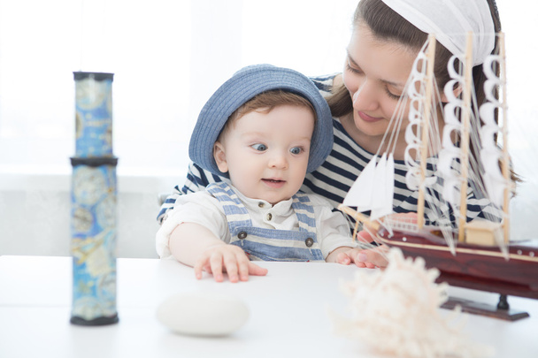Concepto de viaje. Madre y su bebé jugando con el modelo de la nave
. - Foto, imagen