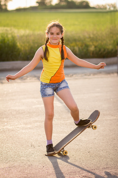 Koncepcja dziecko mody - stylowe małe dziecko dziewczynka noszenie t-shirt z deskorolka w lecie - Zdjęcie, obraz