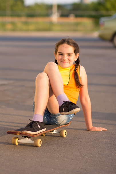 Fashion kid concept - stylish little girl child wearing a t-shirt with skateboard in summer - 写真・画像