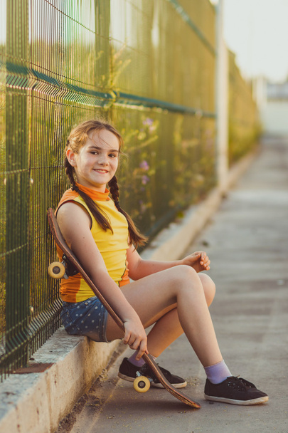 Fashion kid concept - stylish little girl child wearing a t-shirt with skateboard in summer - Valokuva, kuva