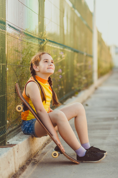 Fashion kid concept - stylish little girl child wearing a t-shirt with skateboard in summer - Fotografie, Obrázek