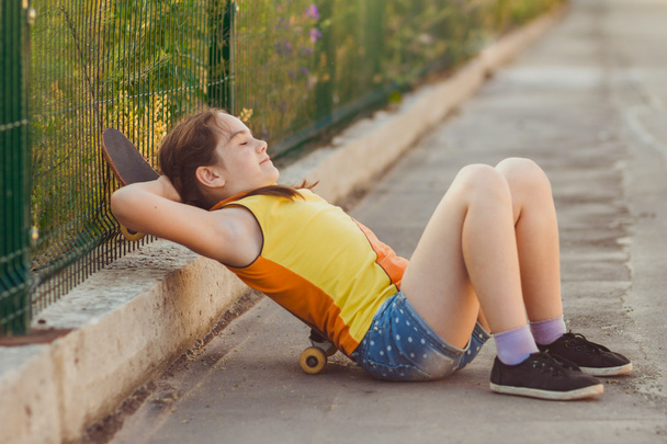 Fashion kid concept - stylish little girl child wearing a t-shirt with skateboard in summer - Zdjęcie, obraz