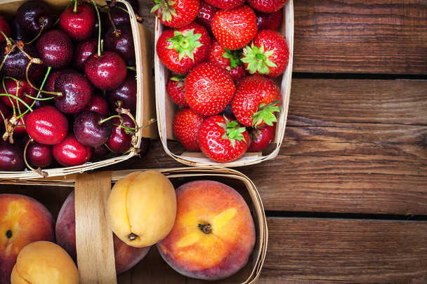 Свіжі стиглі літні ягоди та фрукти в кошиках
 - Фото, зображення