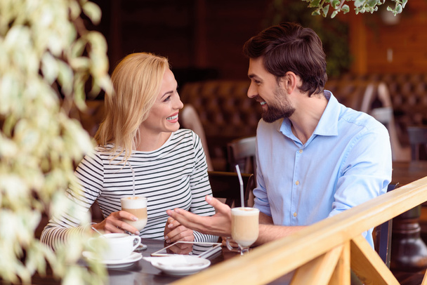 Happy man and woman communicating in cafe - Φωτογραφία, εικόνα