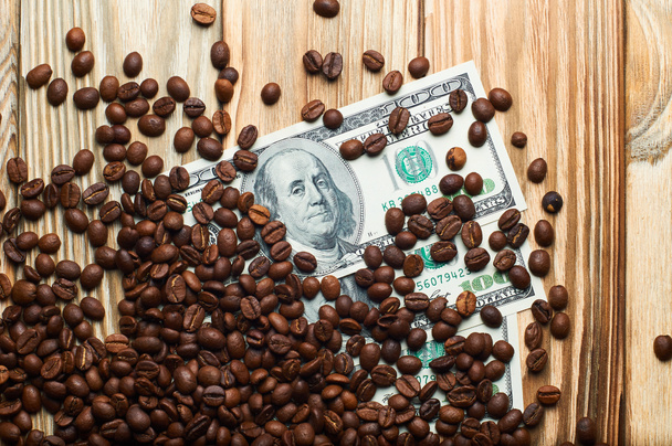 Koffie en geld op een houten tafel. Inkomsten op de koffie. - Foto, afbeelding