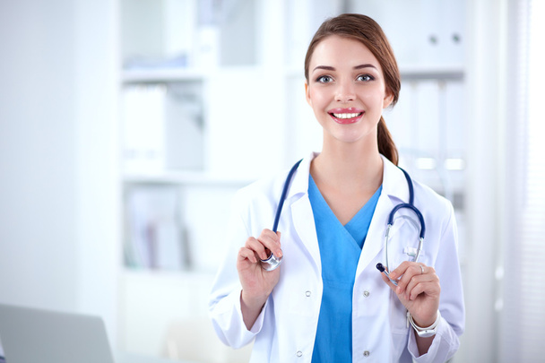 Portrait of young woman doctor with white coat standing in hospital - Foto, Imagen