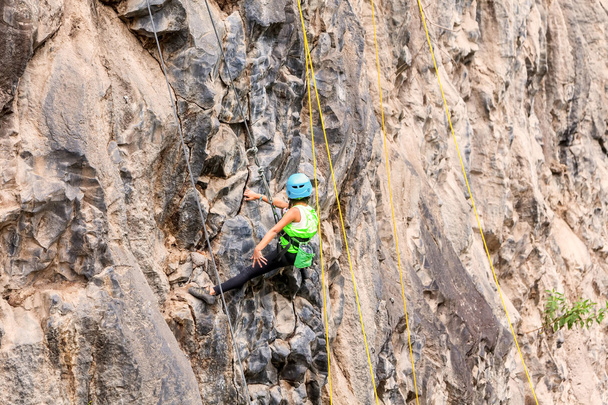 Neidentifikovaný ambiciózní dívka lezení skalní stěna - Fotografie, Obrázek