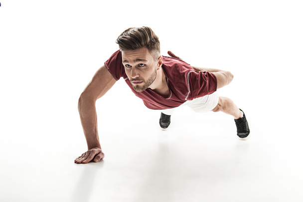 Cheerful male athlete does push-ups - Foto, afbeelding