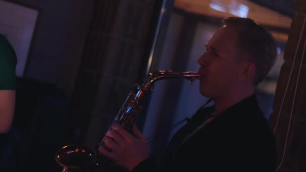 El hombre toca el saxofón en la fiesta en el club nocturno. Realizar. Vacaciones. Animando. Músico.
 - Imágenes, Vídeo