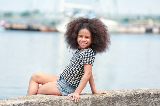 Afro American  little girl wearing stylish clothes outdoors. Fashion kid concept - Photo, Image