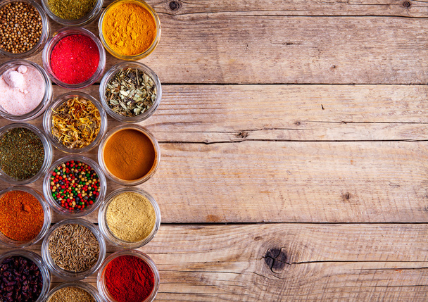 Spices in jars on wooden background. Food - Zdjęcie, obraz