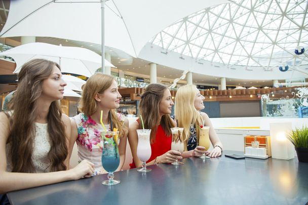 Close up four attractive young women drinking cocktails in shopp - Фото, зображення