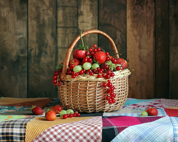 Still life with berries in a basket in a rustic style. - Photo, Image