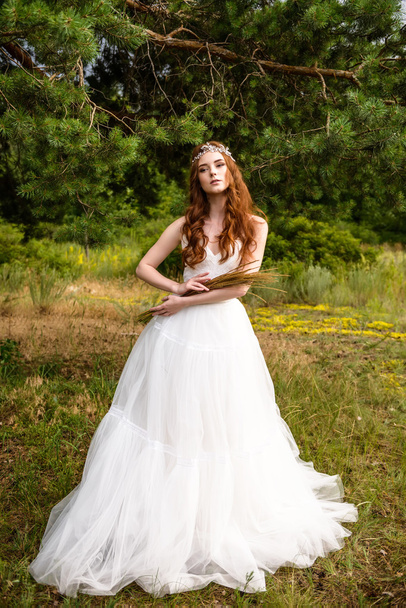 Redheaded young girl in the woods. Portrait of the bride in the Park. A girl holds wheat ears in the hands. hippie girl - Photo, Image
