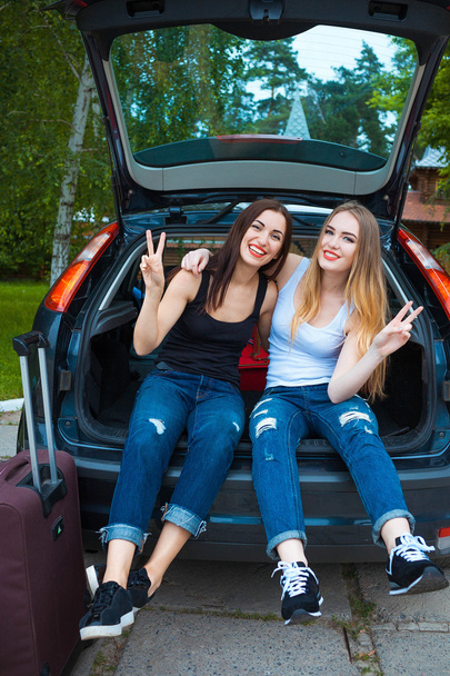 Kaksi tyttöä poseeraa autossa
 - Valokuva, kuva