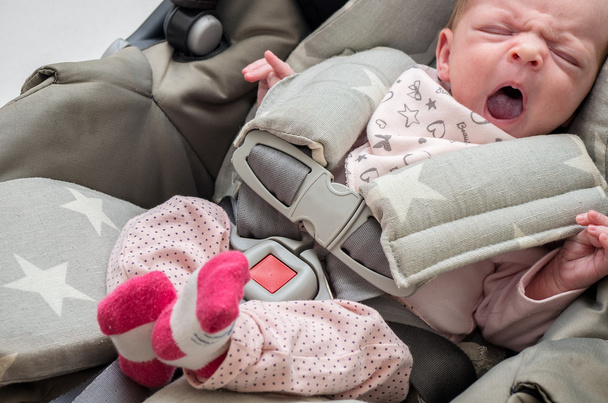 pasgeboren babymeisje in een autostoel - Foto, afbeelding