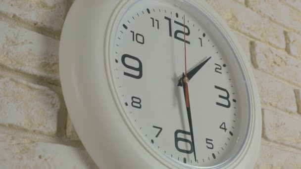 Zeit eine Stunde 30 Minuten. Zeitraffer. Runde weiße Uhr hängt an Ziegelwand. - Filmmaterial, Video