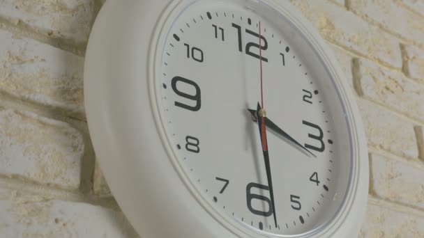 Zeit drei Stunden dreißig Minuten. Zeitraffer. Runde weiße Uhr hängt an Ziegelwand. - Filmmaterial, Video