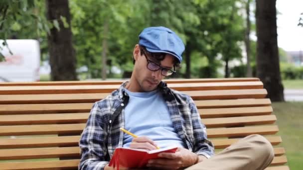 Man drawing to sketchbook with pencil on street - Video
