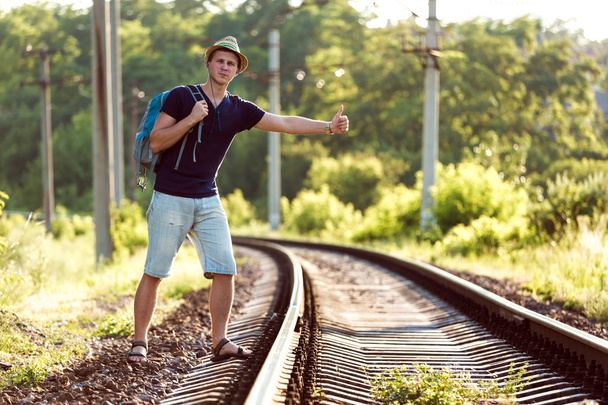 Young Man in Travel Clothing hitch hiking rural Railroad Train - Foto, Bild